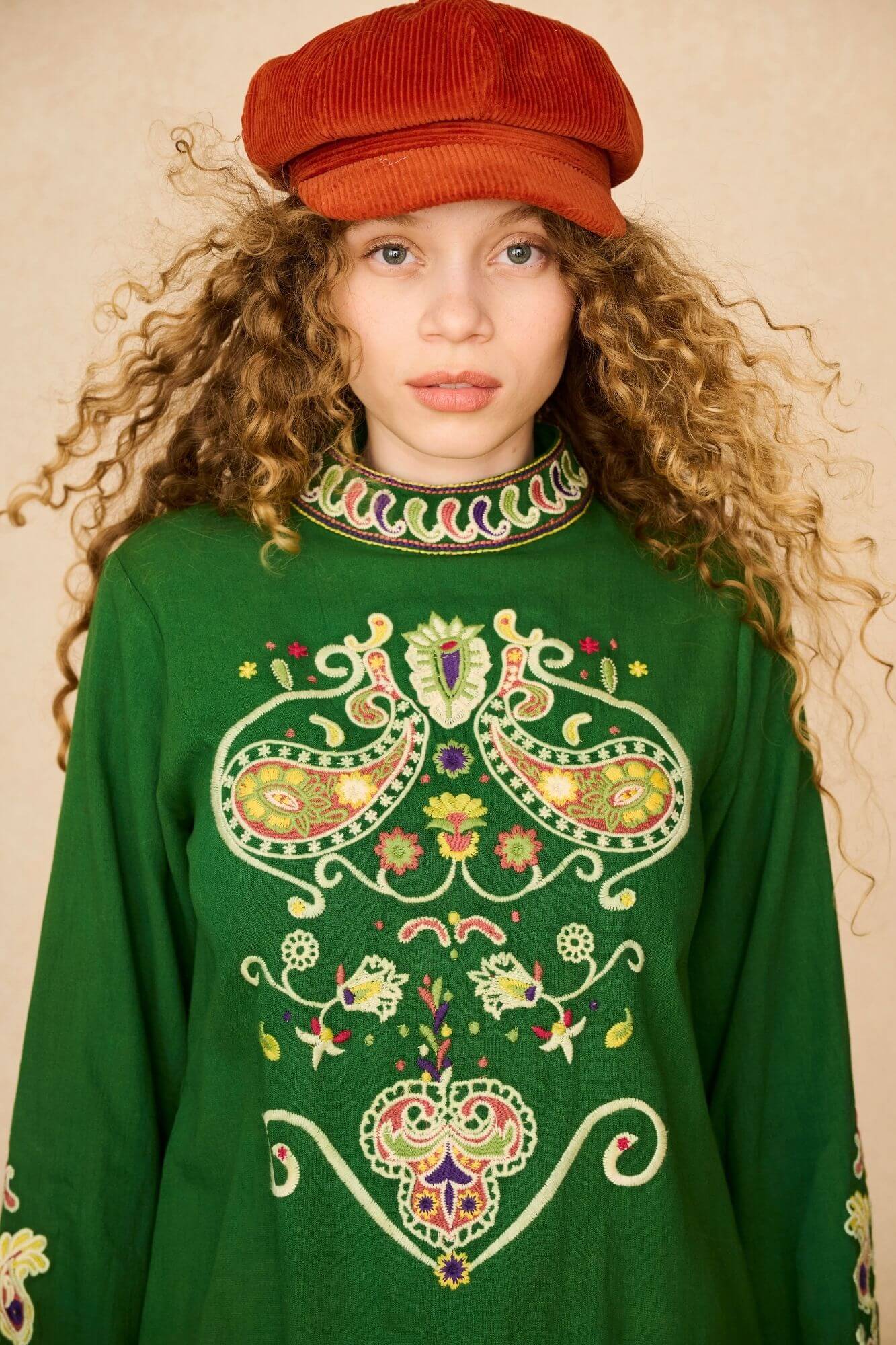 Model wears a 70s green embroidered mini dress with brown penny lane boots by The Hippie Shake