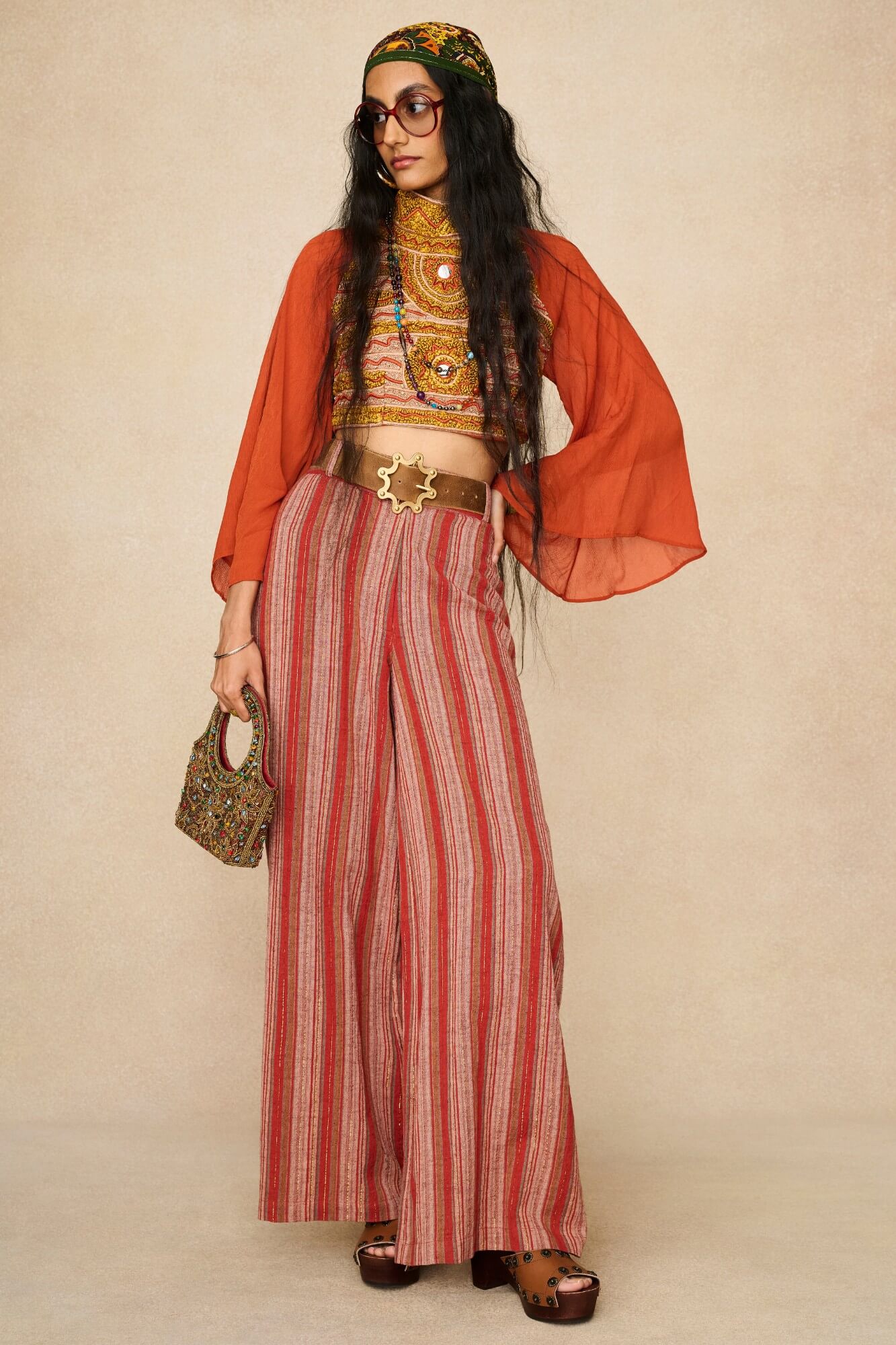 Model wearing 70s orange beaded top with striped trousers by The Hippie Shake, front view