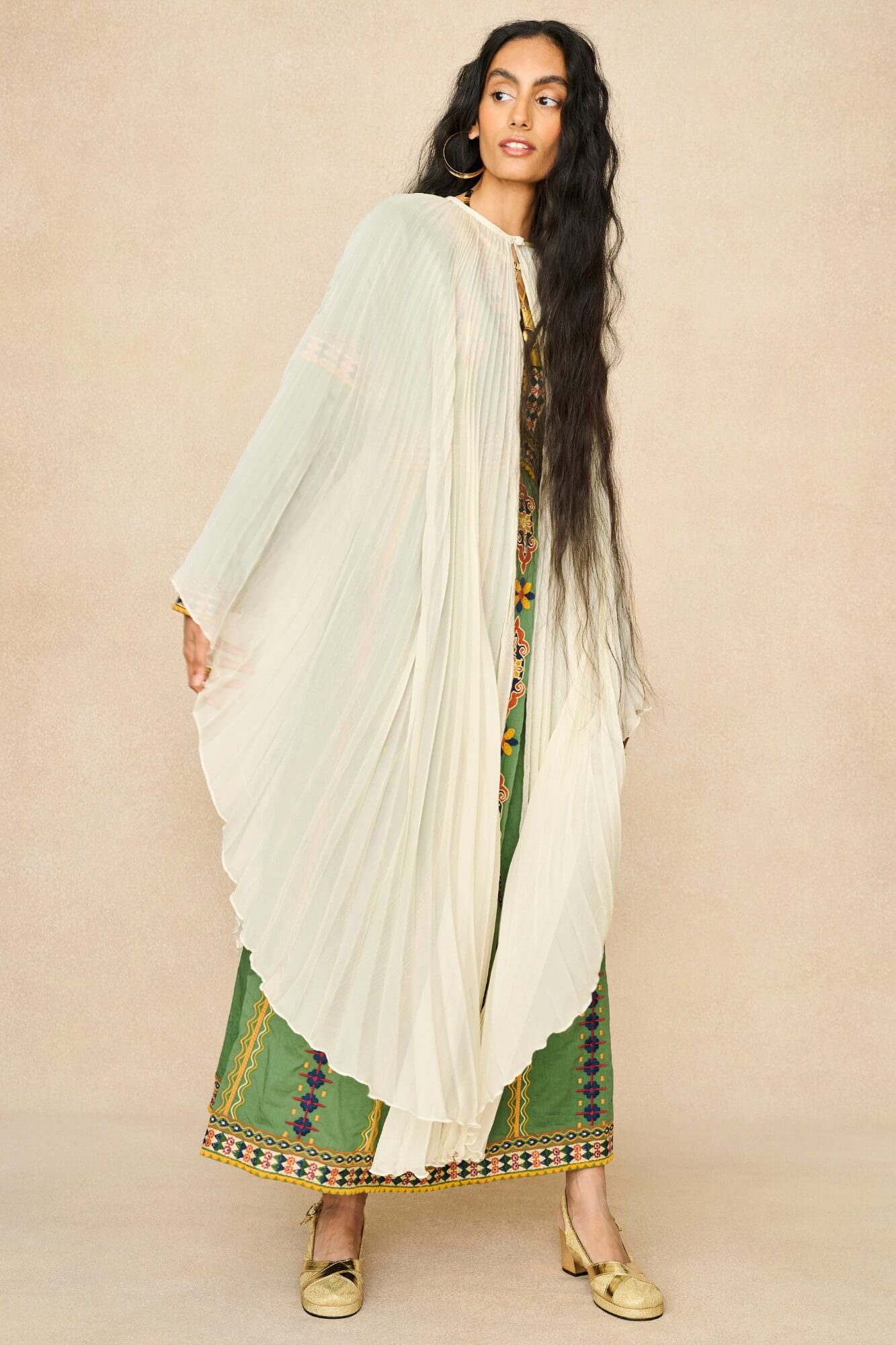 Model wearing 70s cream cape by The Hippie Shake, side view