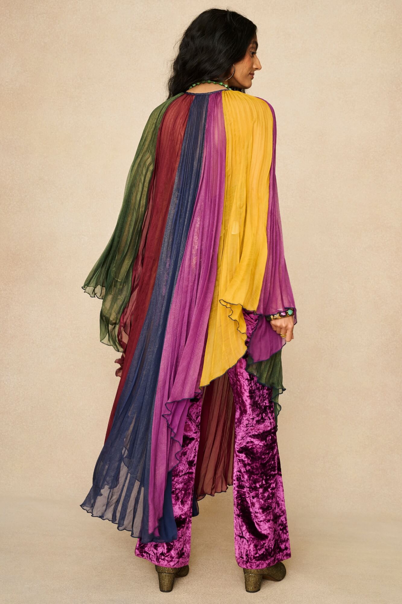 Model wearing rainbow striped cape by The Hippie Shake, back view