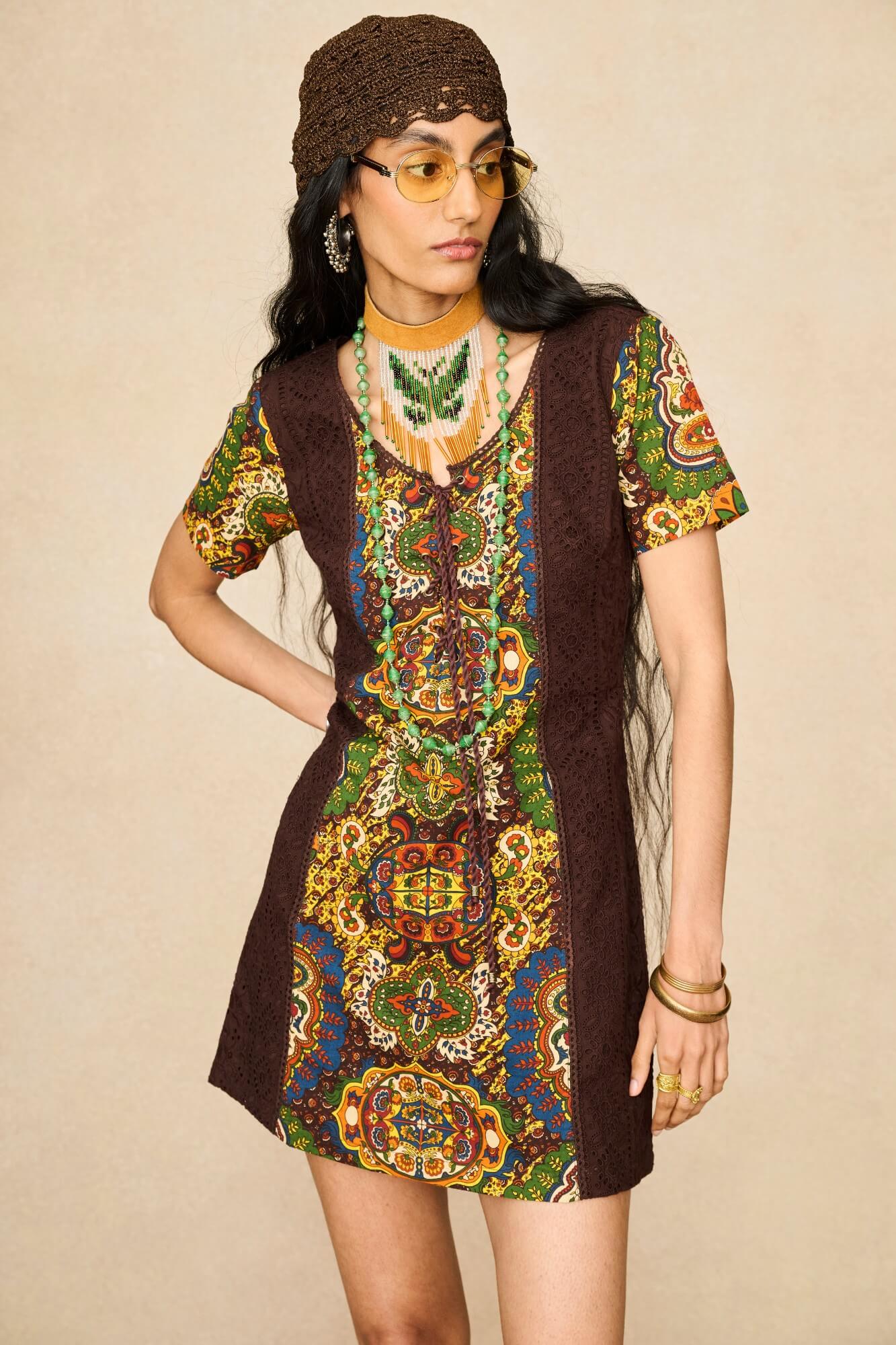 Model wearing 70s tapestry printed mini dress in brown by The Hippie Shake, front view