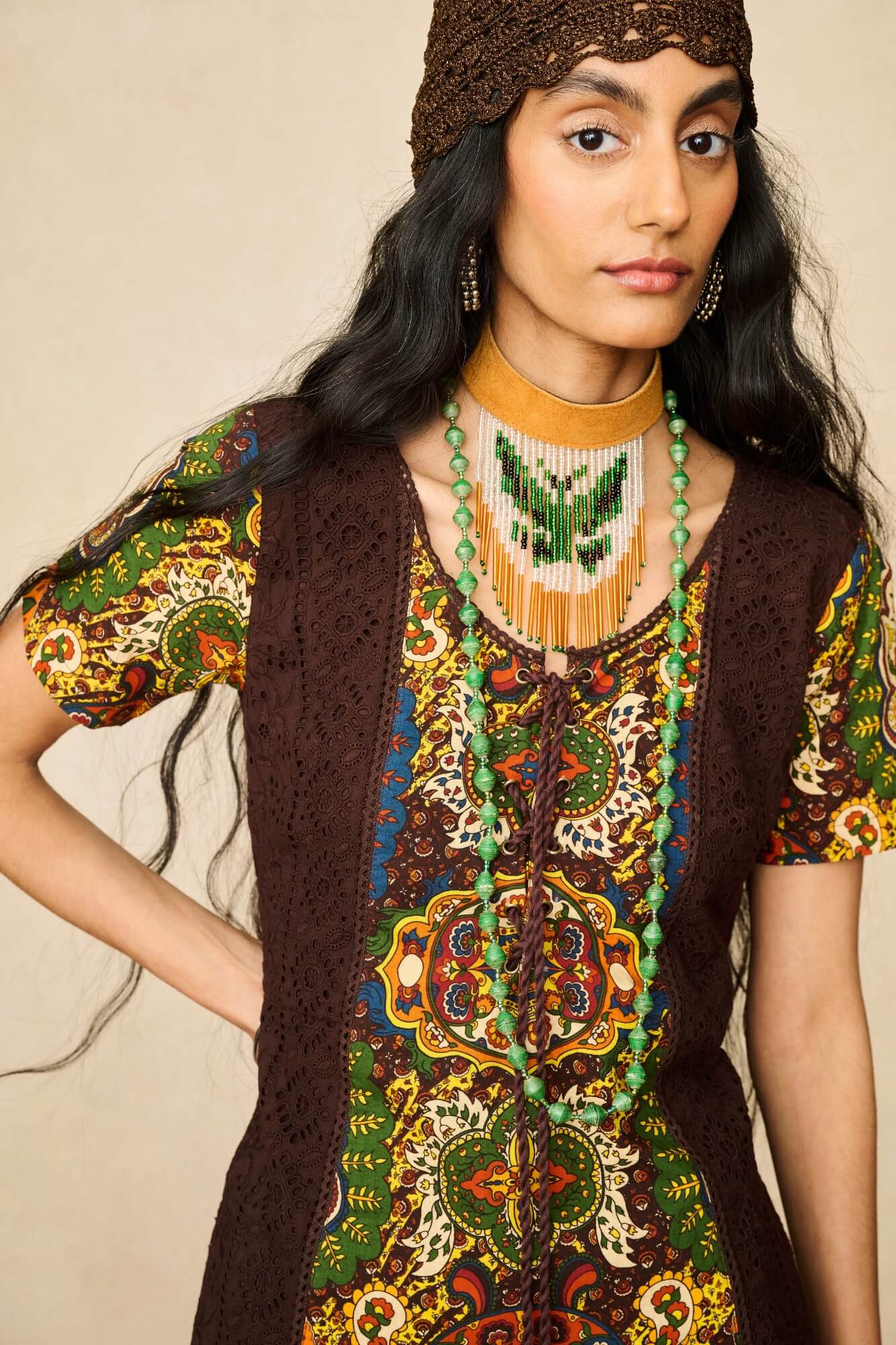 Model wearing 70s tapestry printed mini dress in brown by The Hippie Shake, close up