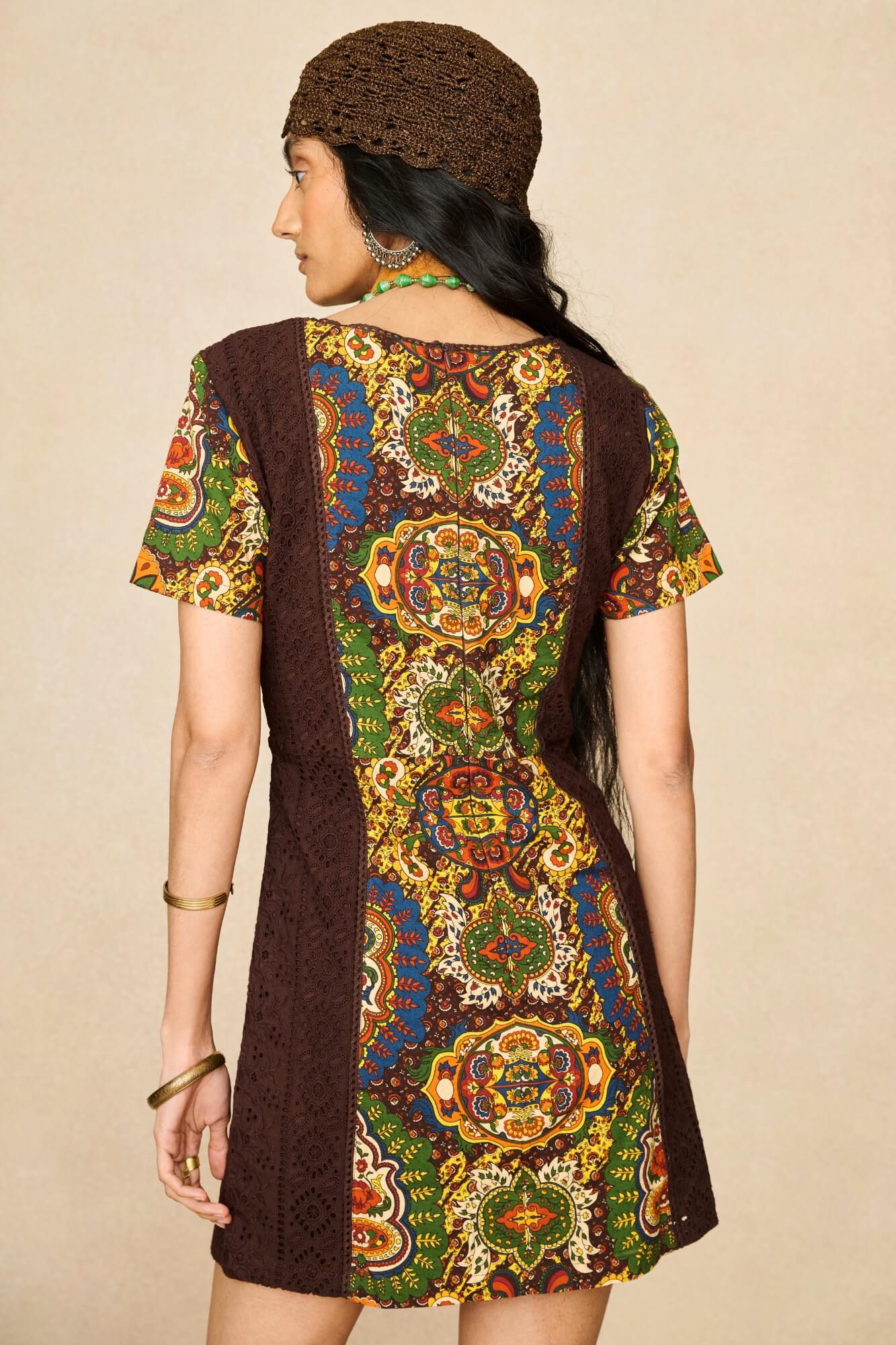 Model wearing 70s tapestry printed mini dress in brown by The Hippie Shake, back view