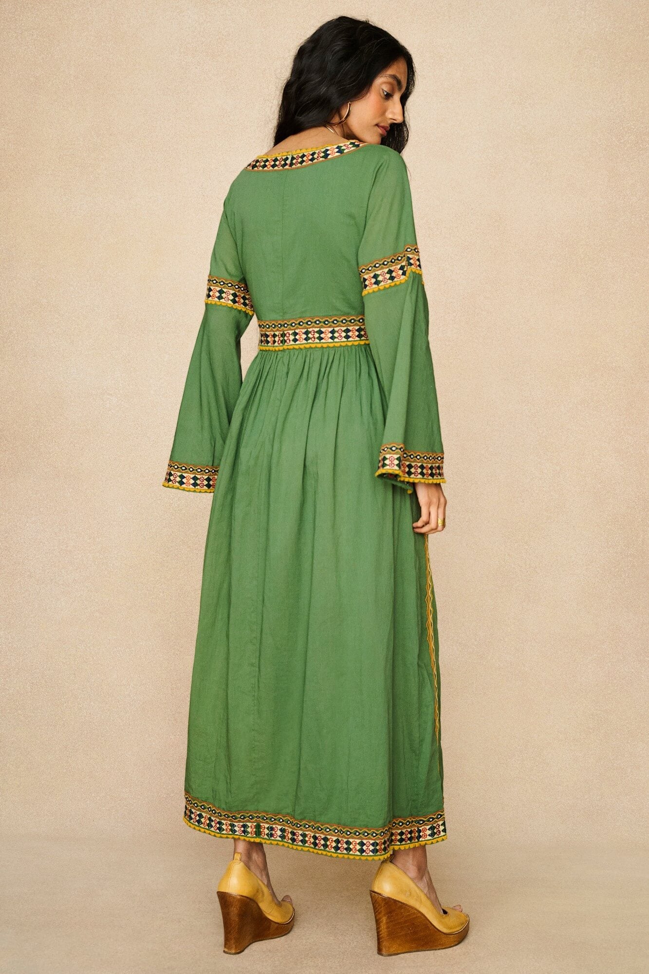 Model wearing 70s green embroidered maxi dress by The Hippie Shake, back view