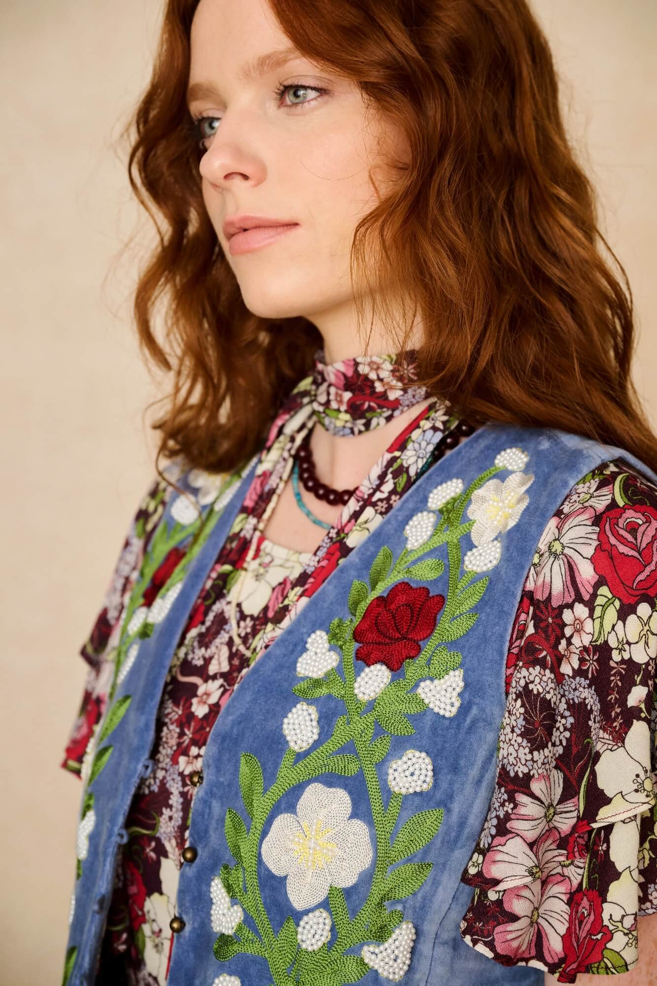 woman wears embroidered blue vest - close up