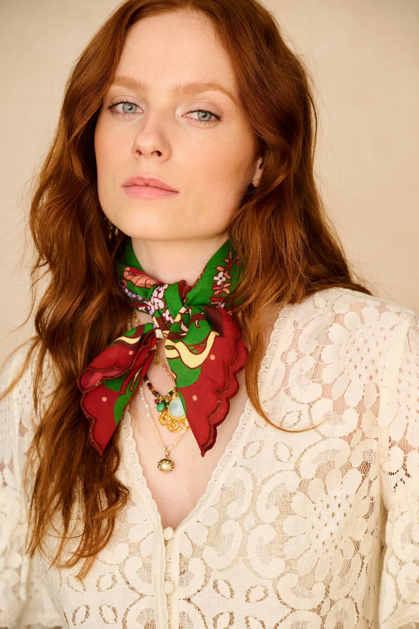 Woman wearing a colorful scarf with a neutral background