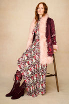 woman wears floral dress with penny lane coat in burgundy