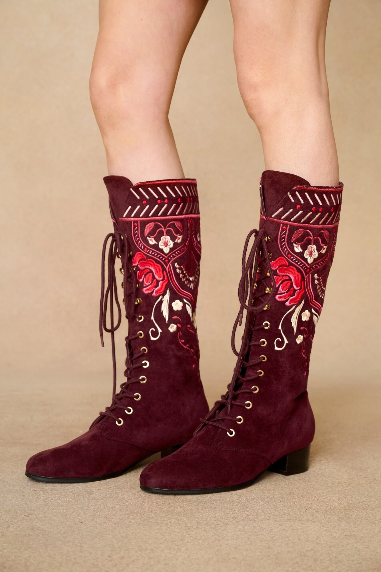 Model wearing burgundy lace-up Penny Lane boots with penny lane coat from Pamela Des Barres collection by The Hippie Shake, close up