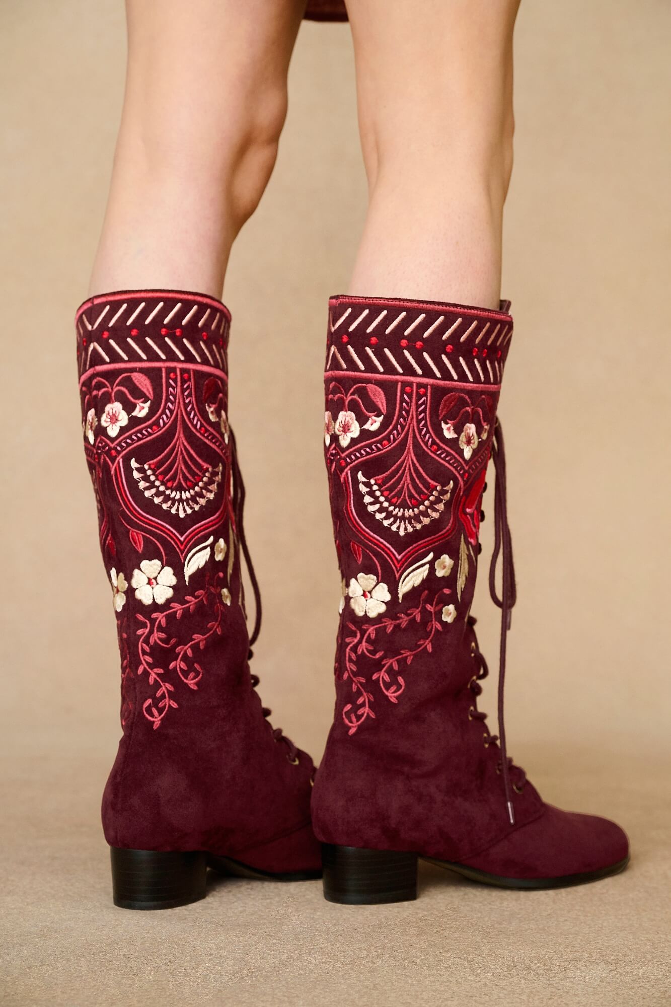 Model wearing burgundy lace-up Penny Lane boots with penny lane coat from Pamela Des Barres collection by The Hippie Shake, close up