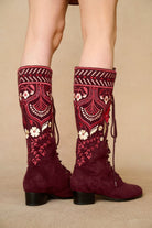 Model wearing burgundy lace-up Penny Lane boots with penny lane coat from Pamela Des Barres collection by The Hippie Shake, close up