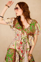 Woman wearing a colorful floral dress against a beige background - close up