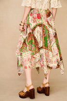 Person wearing a colorful patchwork skirt on a beige background