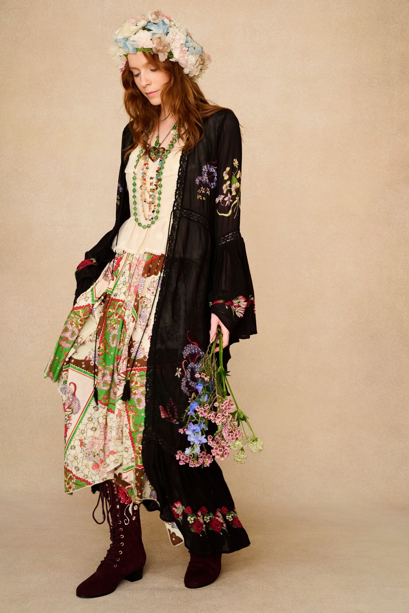 Woman in bohemian outfit with floral headpiece and accessories on a beige background