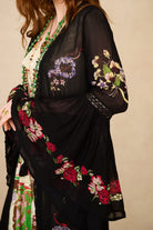 Black embroidered duster with colorful floral patterns on a beige background