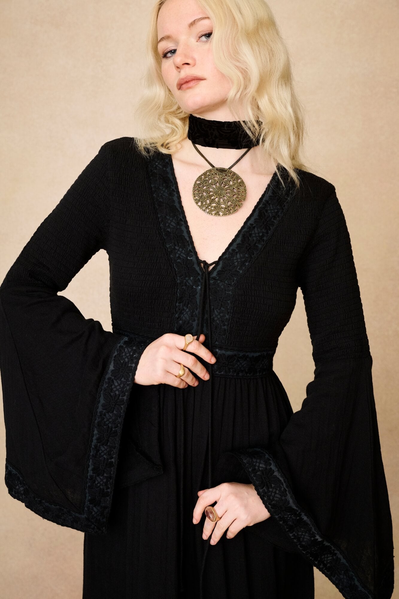 Model wearing 70s black long sleeve maxi dress with lace-up Penny Lane boots by The Hippie Shake, close up view