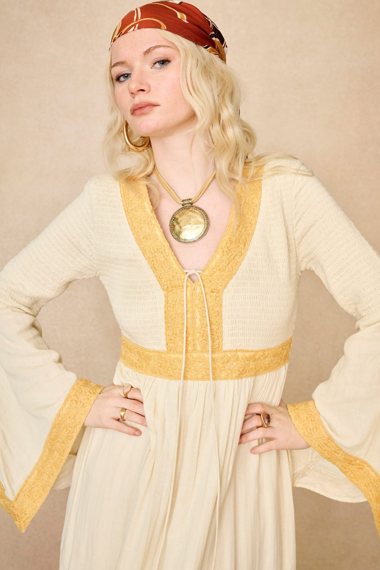 Model wearing 70s cream long sleeve maxi dress with lace-up Penny Lane boots by The Hippie Shake, close up view