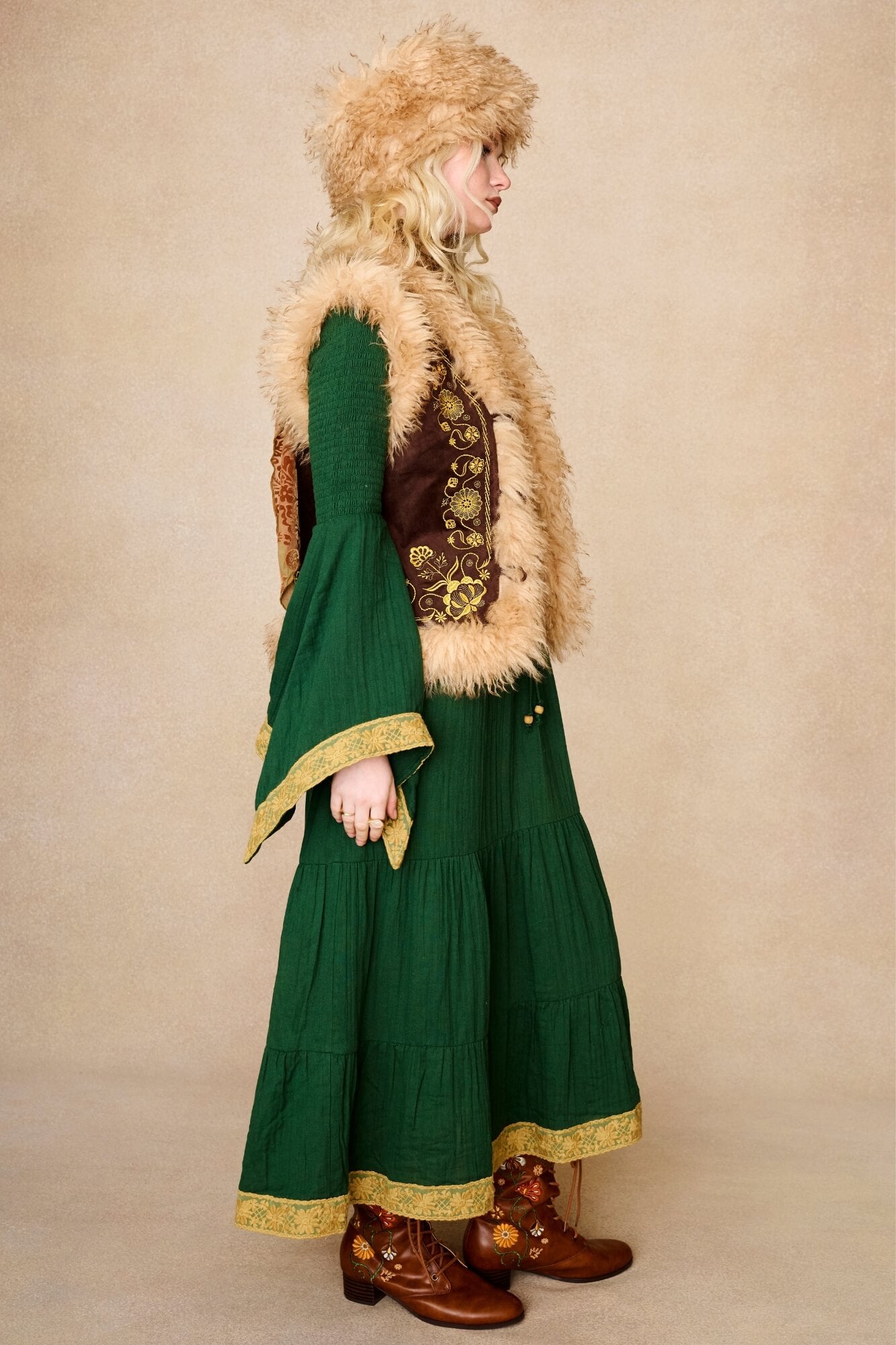 Model wearing 70s green long sleeve maxi dress with lace-up Penny Lane boots by The Hippie Shake, side view