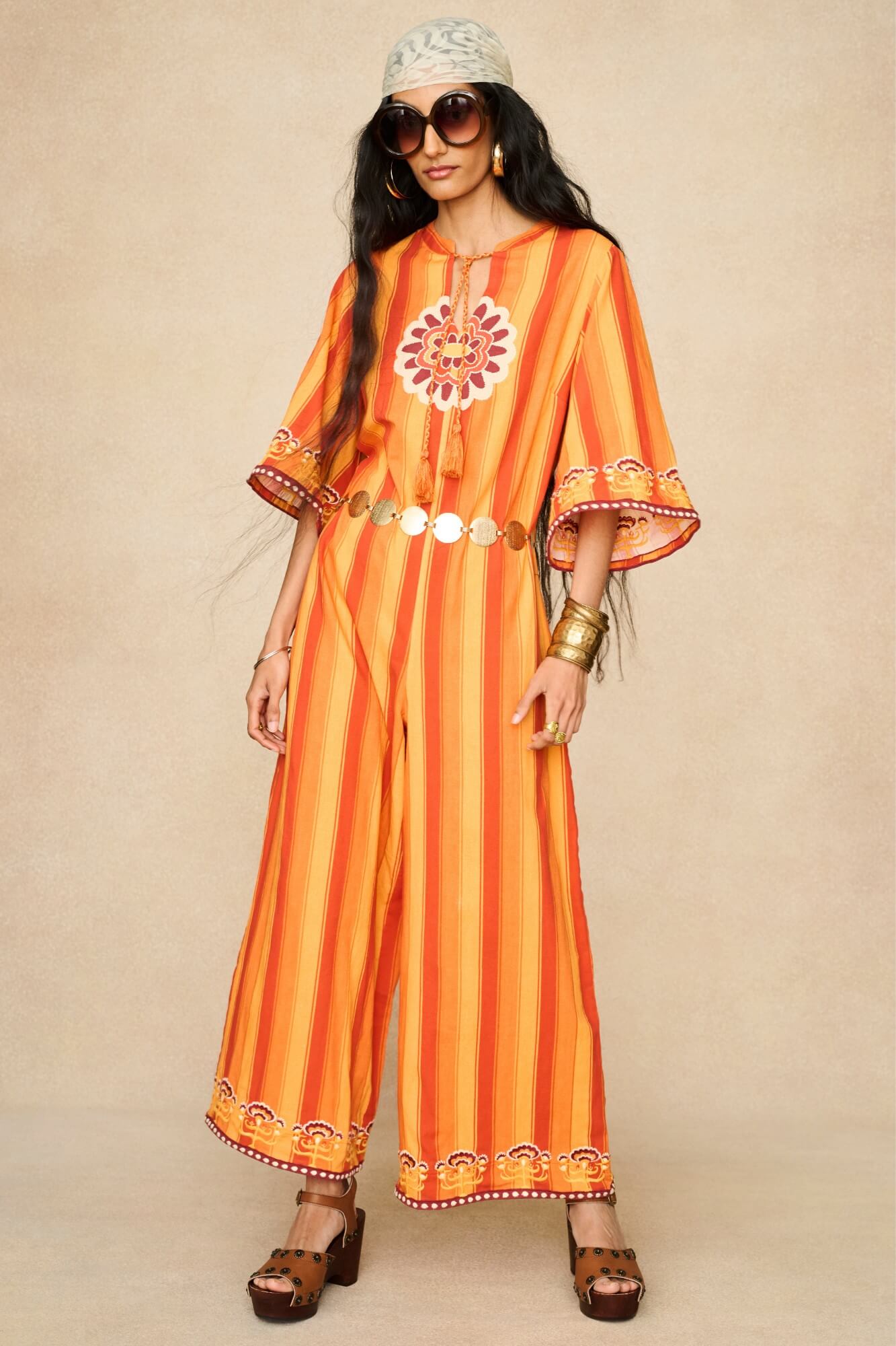 Model wearing 70s orange striped wide leg jumpsuit by The Hippie Shake, front view
