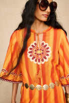 Model wearing 70s orange striped wide leg jumpsuit by The Hippie Shake, close up