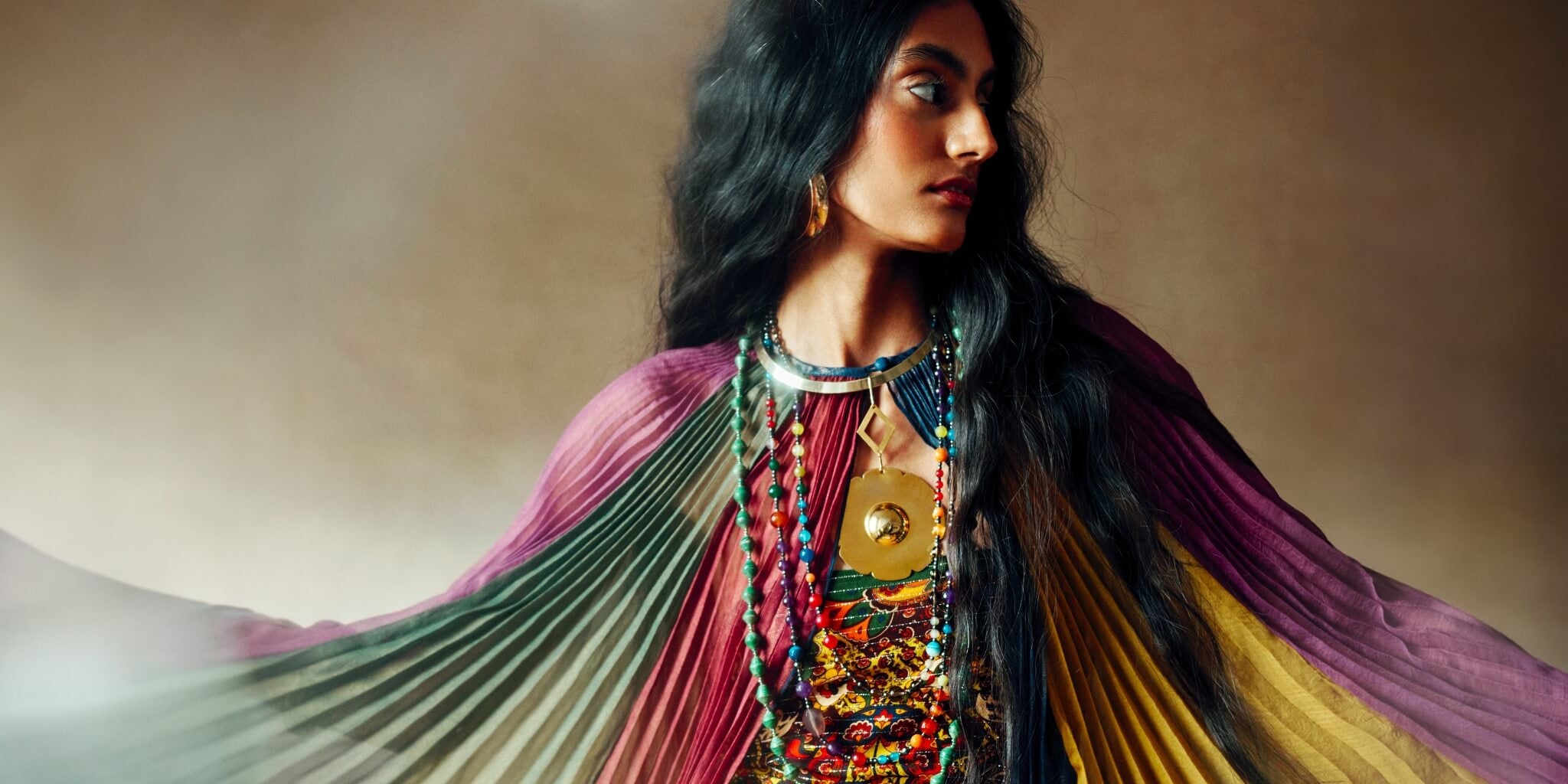 The Hippie Shake Magic Carpet Ride collection banner with model in 70s bohemian rainbow cape.