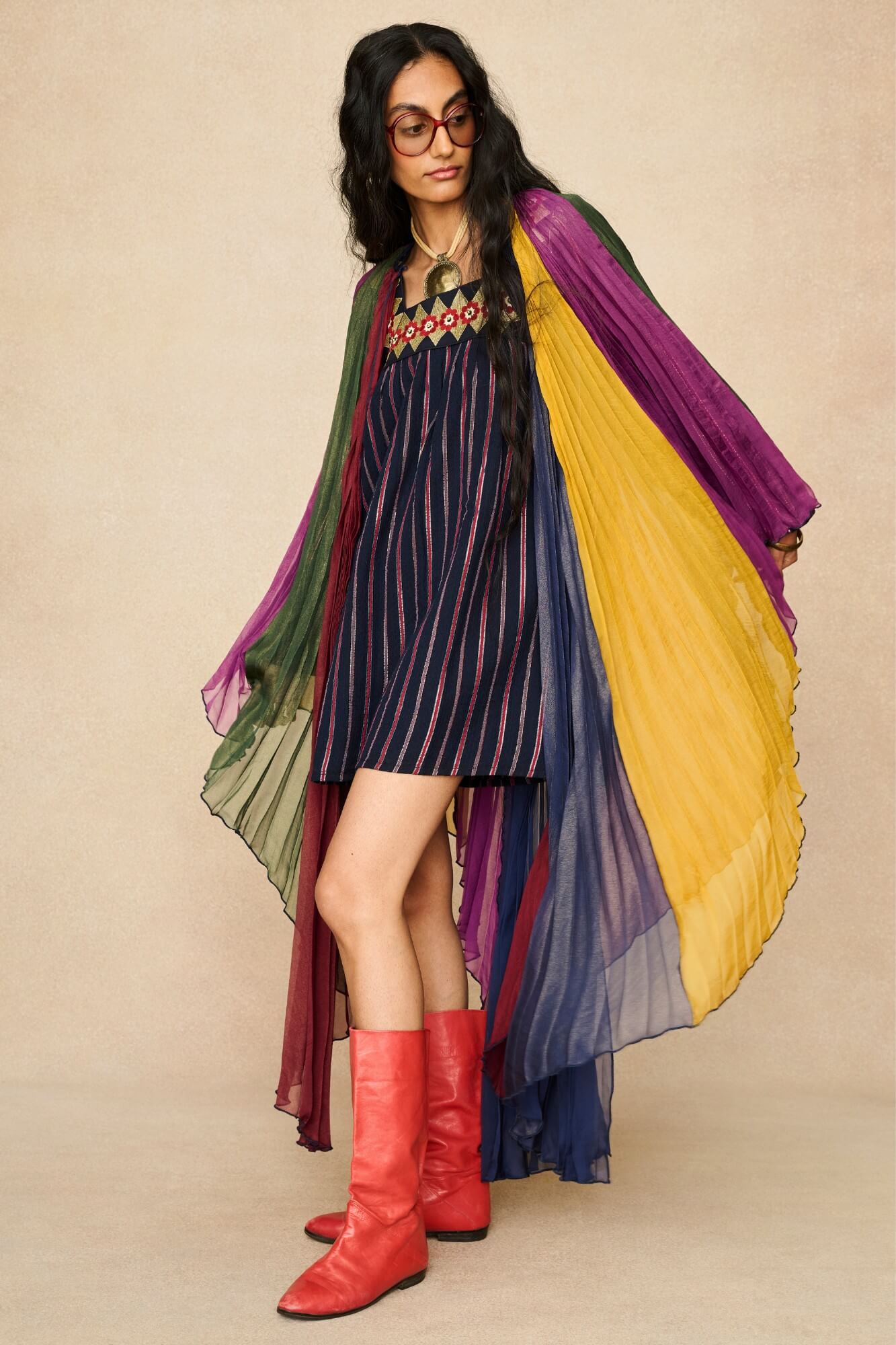 Model wearing 70s striped mini dress styled with a rainbow cape by The Hippie Shake, front view